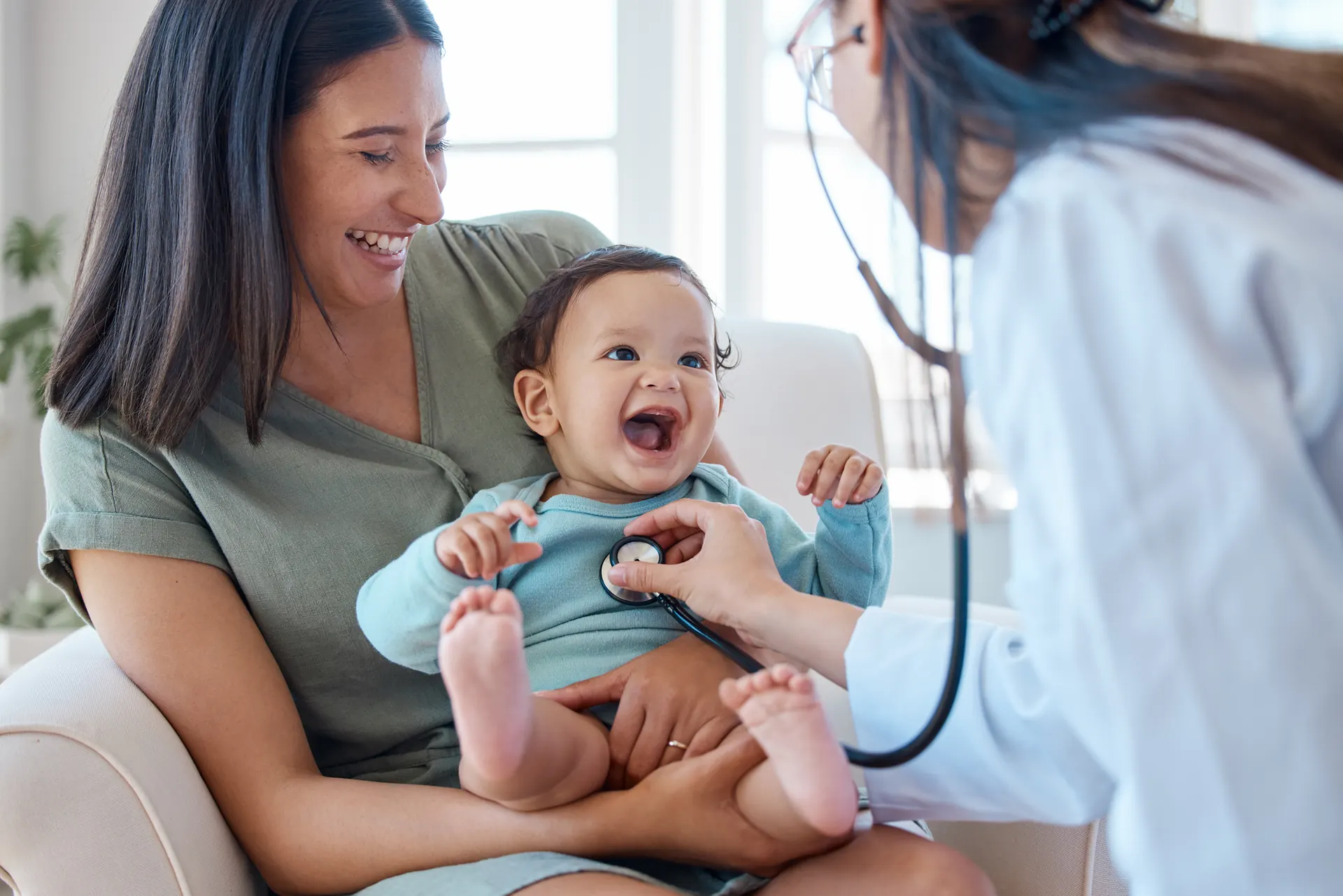 Mãe com bebê no colo durante consulta com médica pediatra